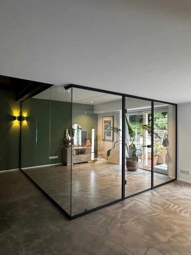 ndividuell geplante Eck-Glastrennwand mit schlankem Profilsystem in Anthrazit. Die raumhohe Verglasung sorgt für Transparenz, klare Linienführung und eine hochwertige Raumstruktur – umgesetzt von Studio 30 in Nordrhein-Westfalen.